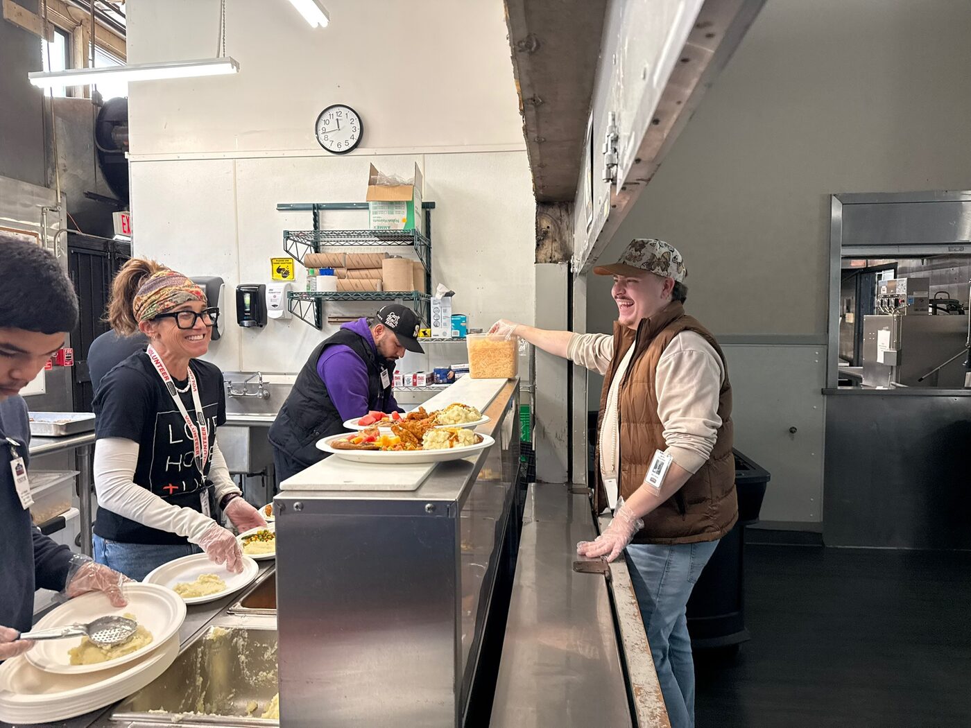 Meghan Hanson and volunteers serving meals along a chow line at a community event