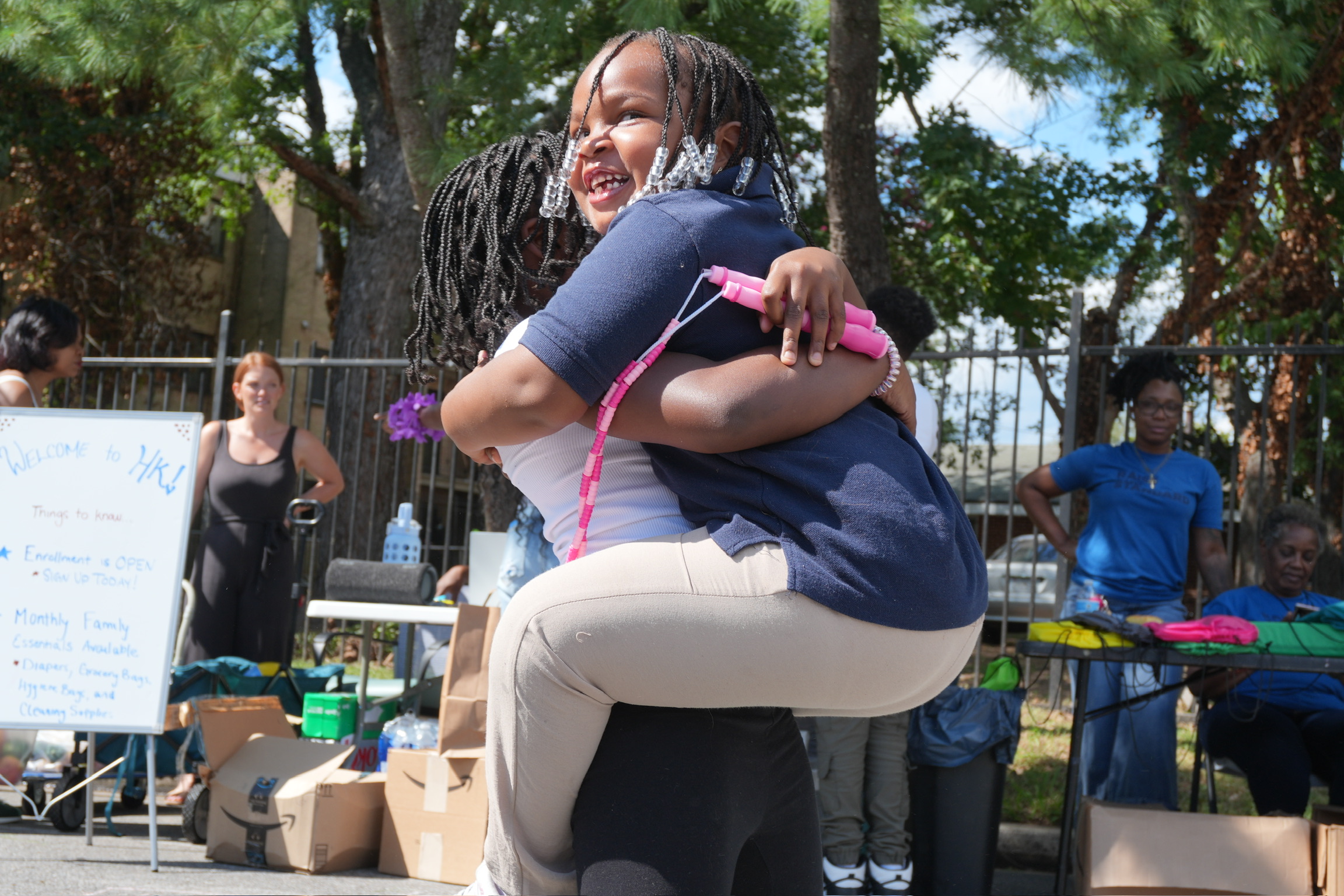 A child hugging a community volunteer at a Roots Foundation event