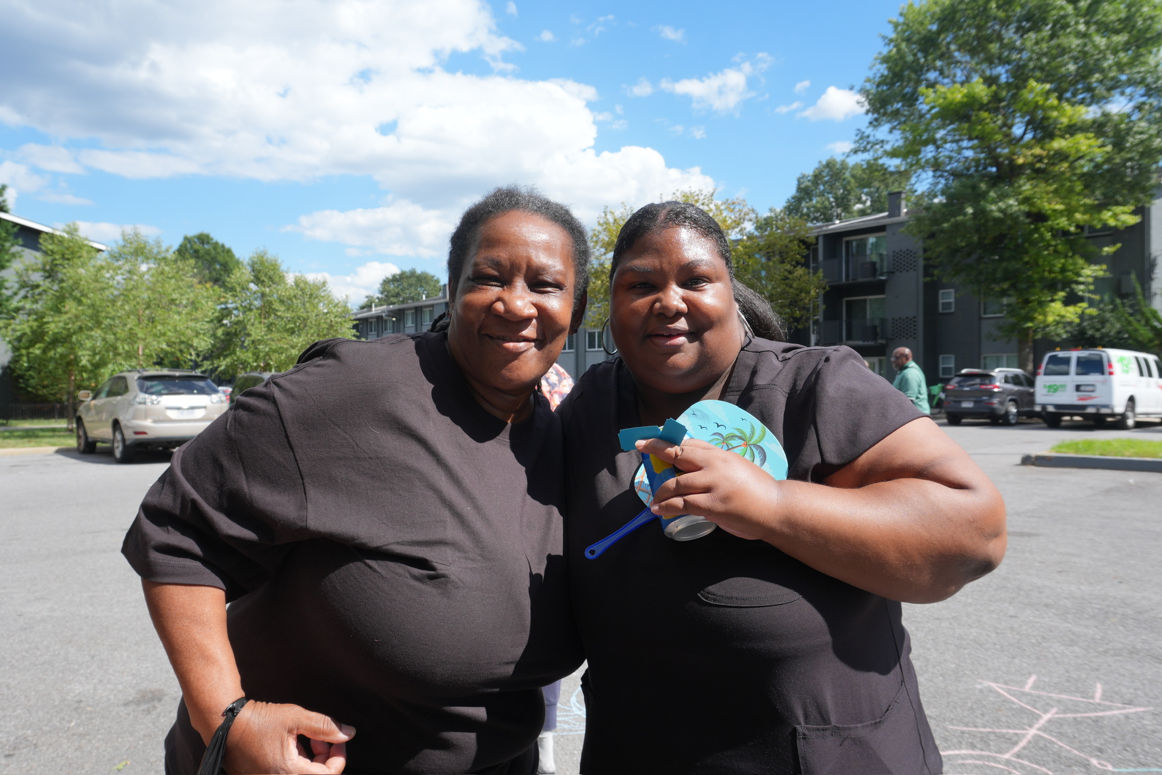 Two women smiling together at a community event